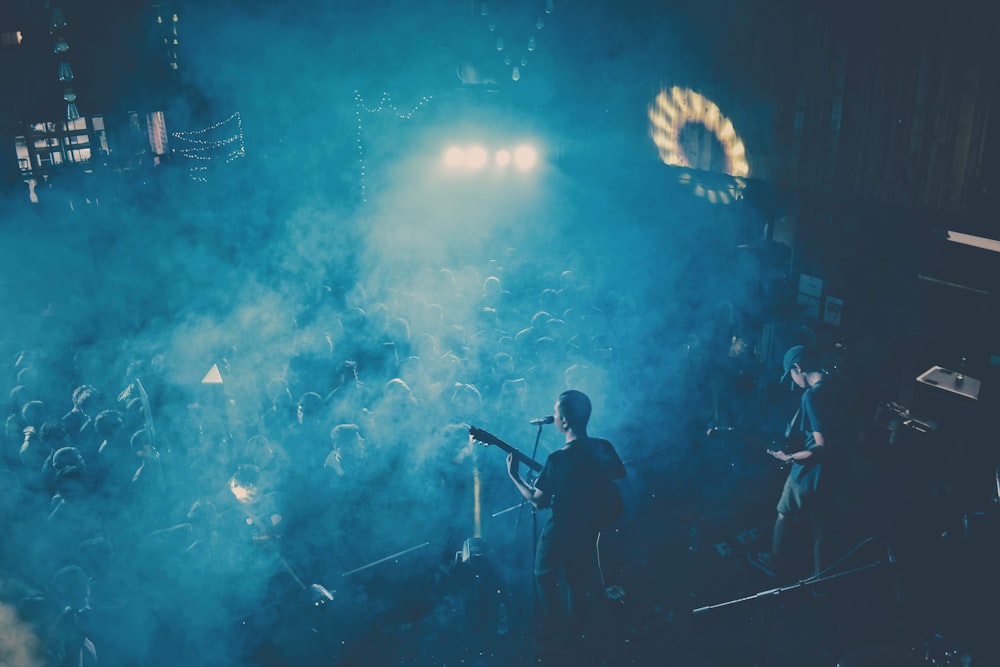 man in black shirt singing on stage