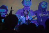 A musician performing passionately on stage with bright lights.