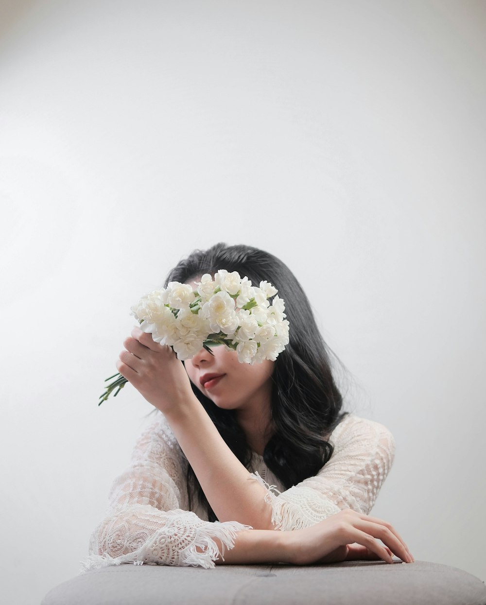 woman in white floral dress holding white flower bouquet