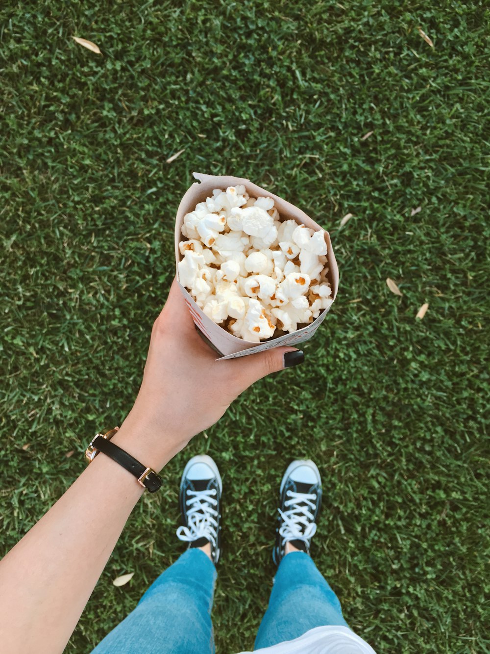 person in blue and white sneakers standing on green grass