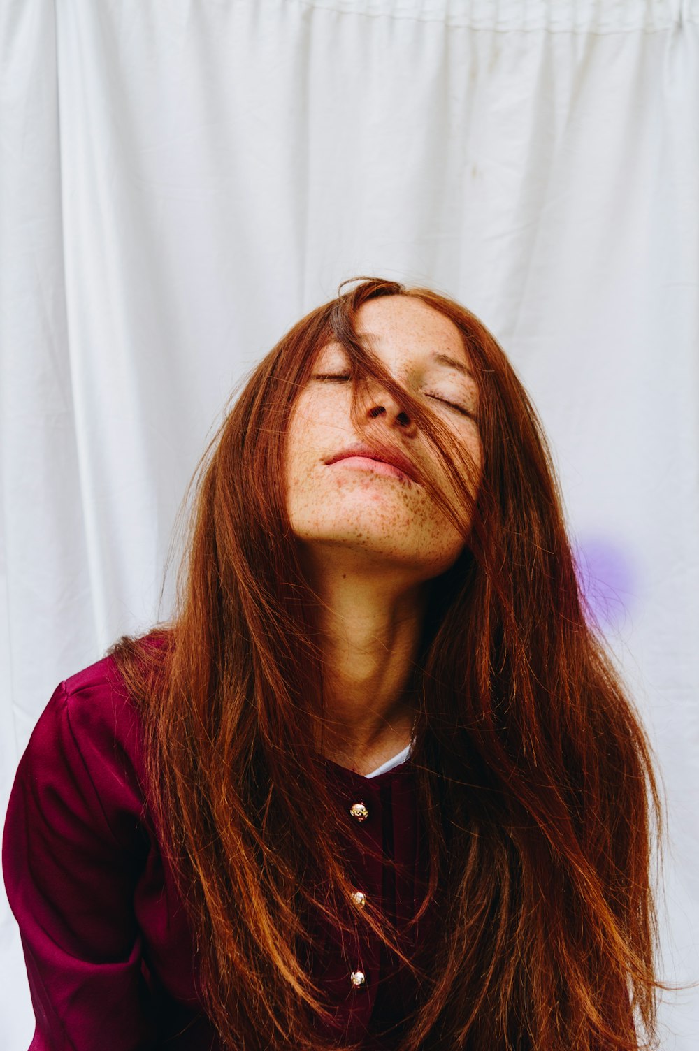 woman in red shirt near white curtain