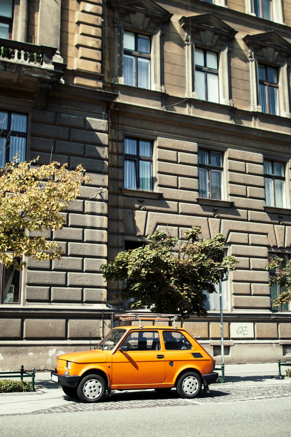 Taxi giallo e nero sulla strada vicino all'edificio di cemento marrone durante il giorno