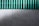 A concrete wall with a green corrugated sheet above it. The wall has a textured surface with visible holes and marks. The corrugated sheet is translucent and contrasts with the wall.