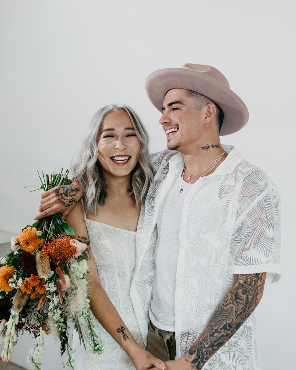 man and woman holding bouquet of flowers