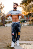 A client showing off toned arms in a summer tee during an outdoor Queens workout.