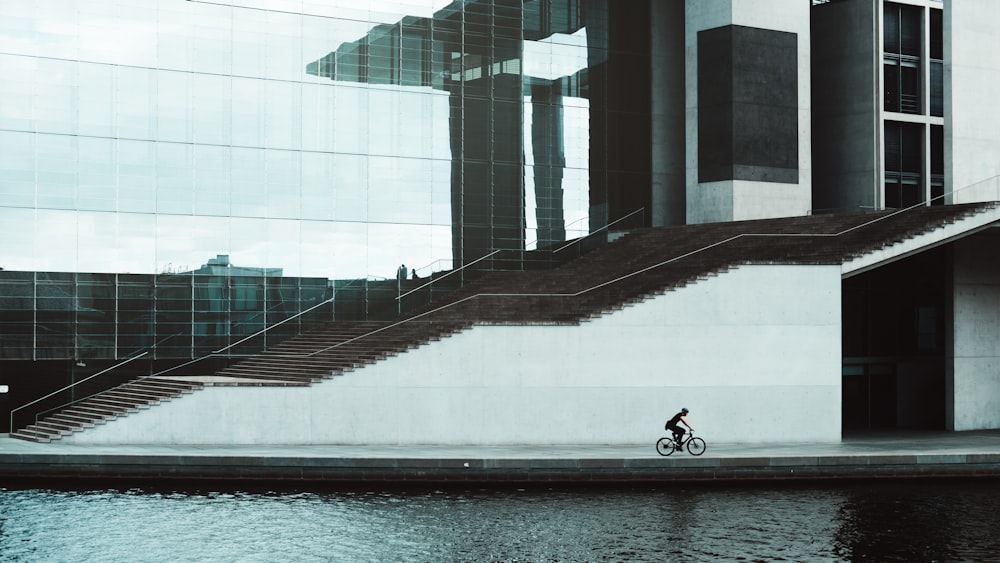 person in black jacket sitting on white concrete bench