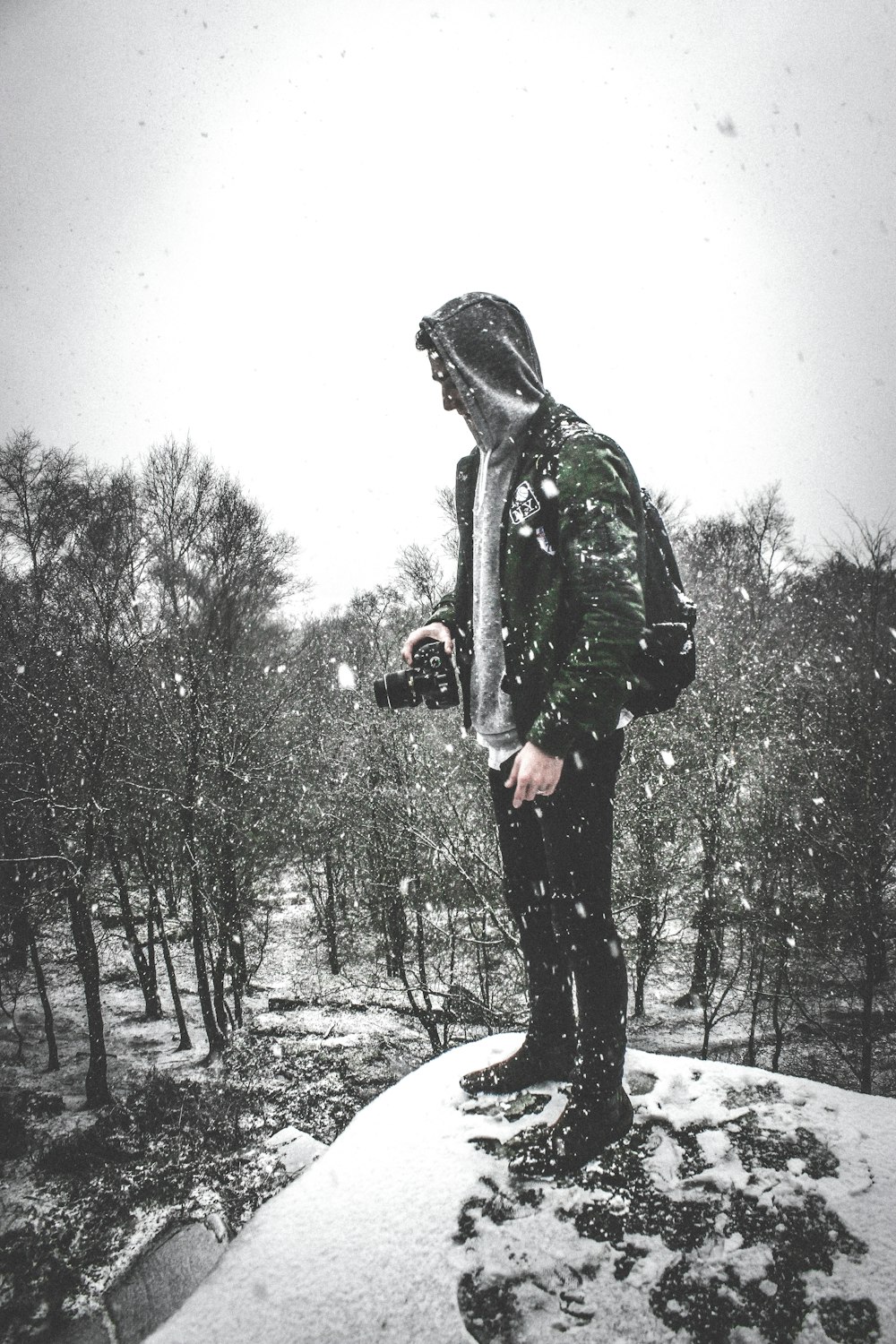 man in black jacket and pants standing on snow covered ground