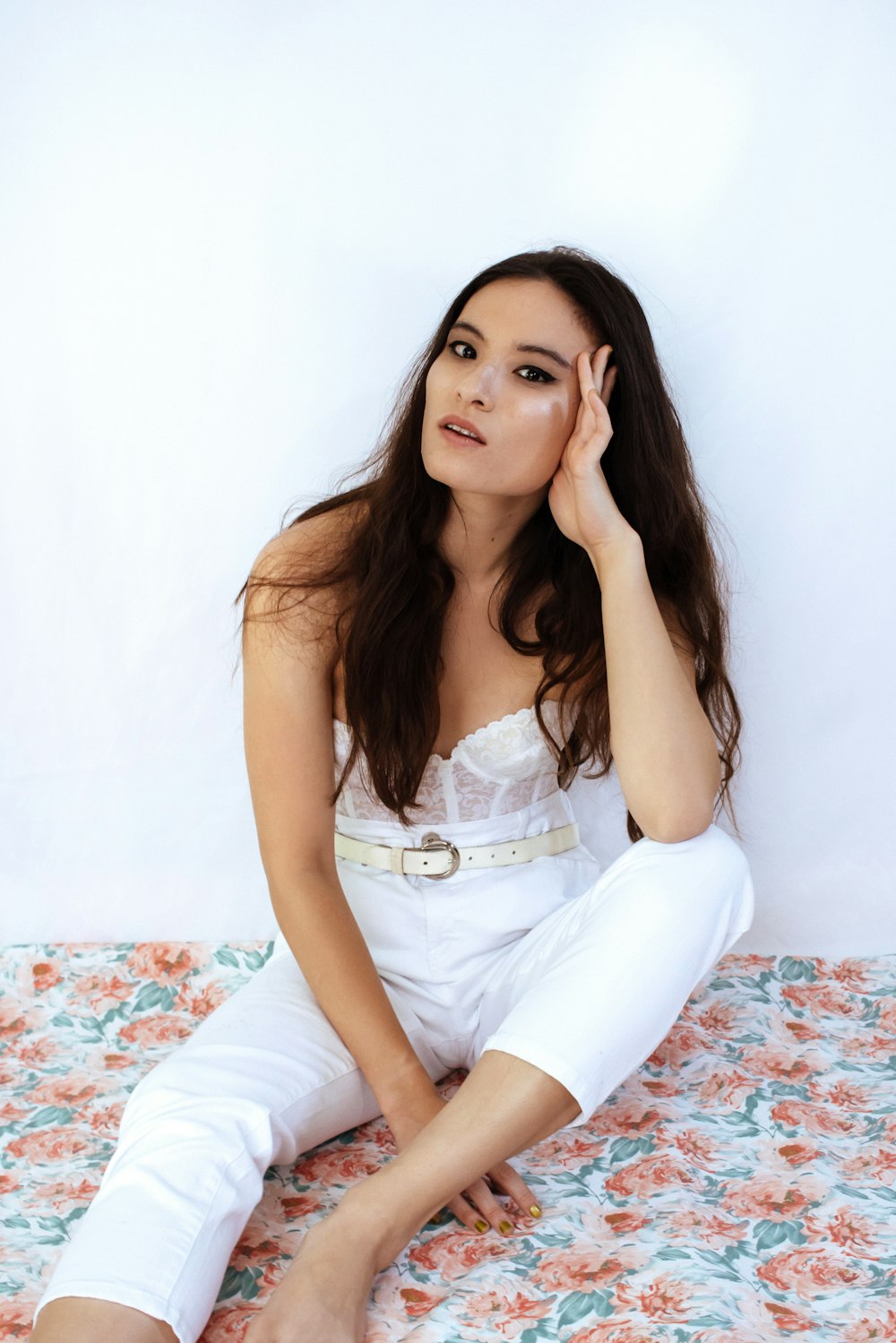 woman in white sleeveless dress sitting on bed