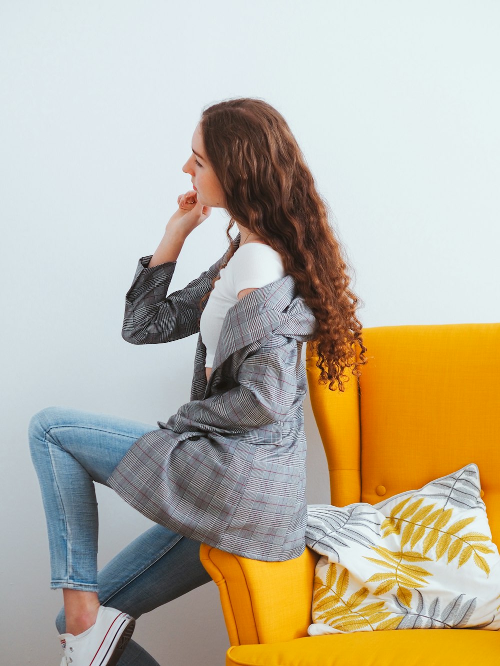 woman in blue denim jacket and blue denim jeans sitting on yellow couch