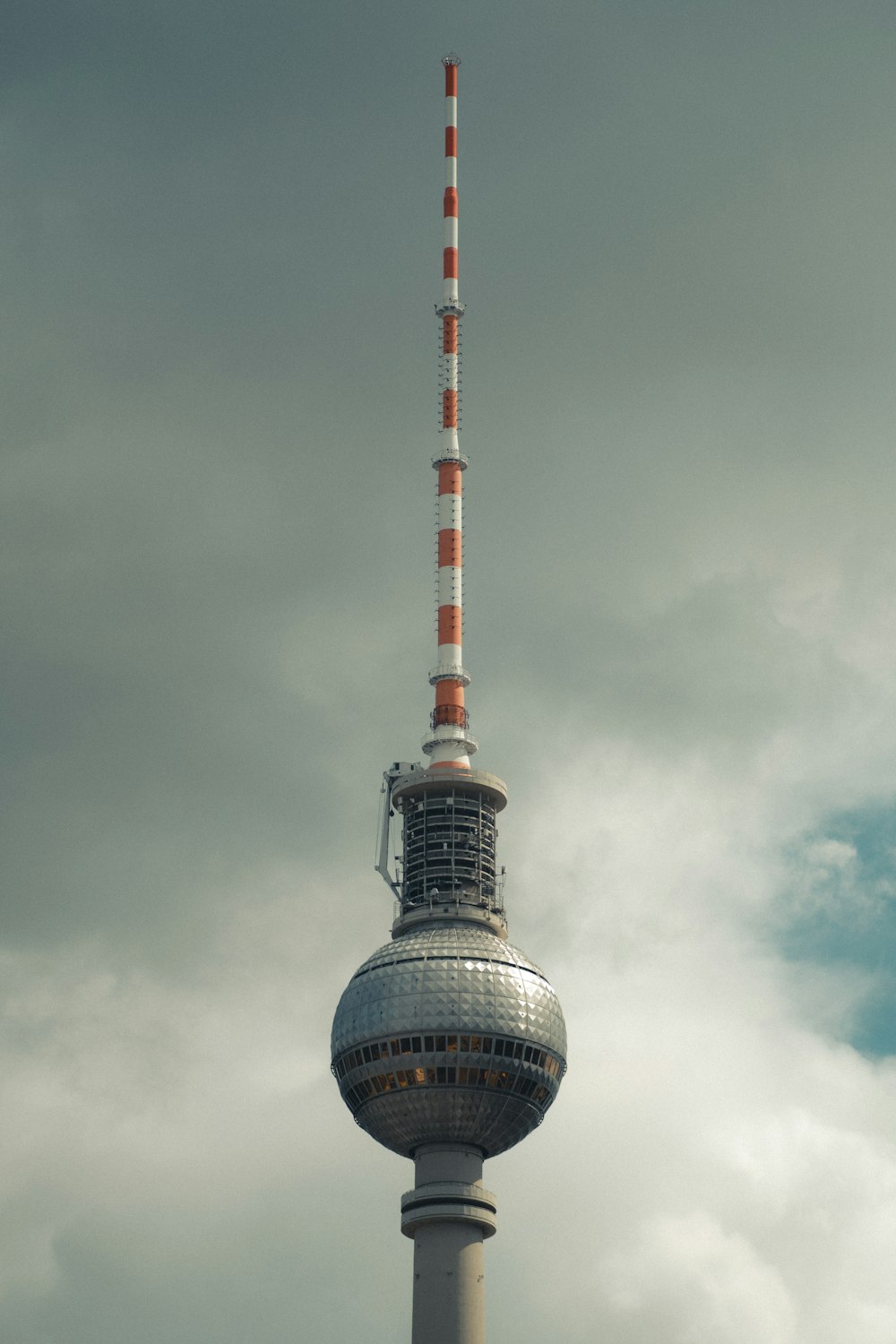 white and red tower under cloudy sky
