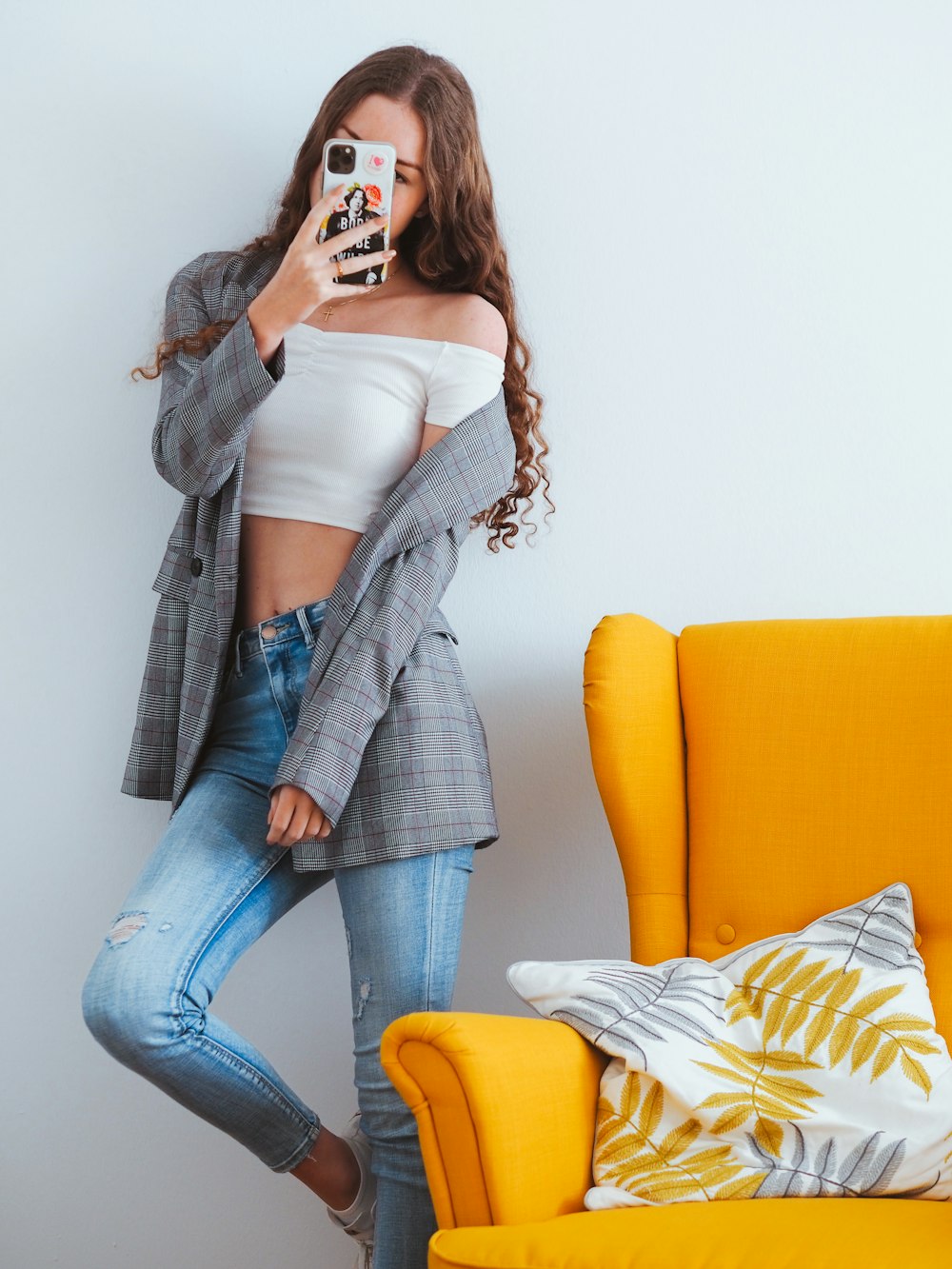 woman in blue denim jeans sitting on yellow couch