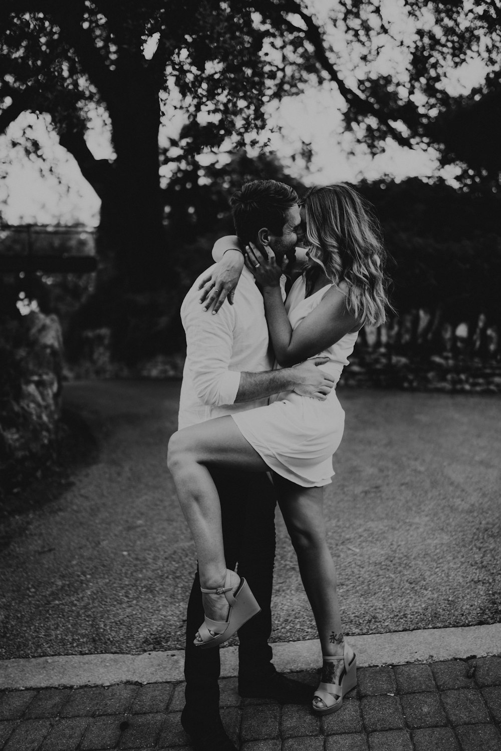 grayscale photo of woman kissing mans cheek