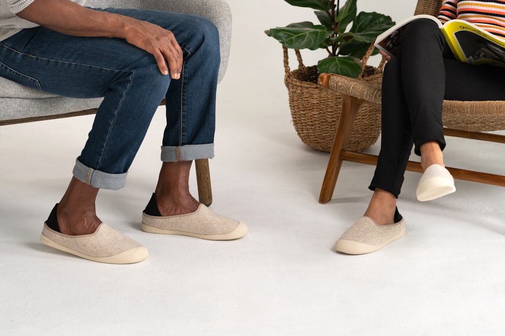 person in blue denim jeans and brown shoes sitting on gray sofa