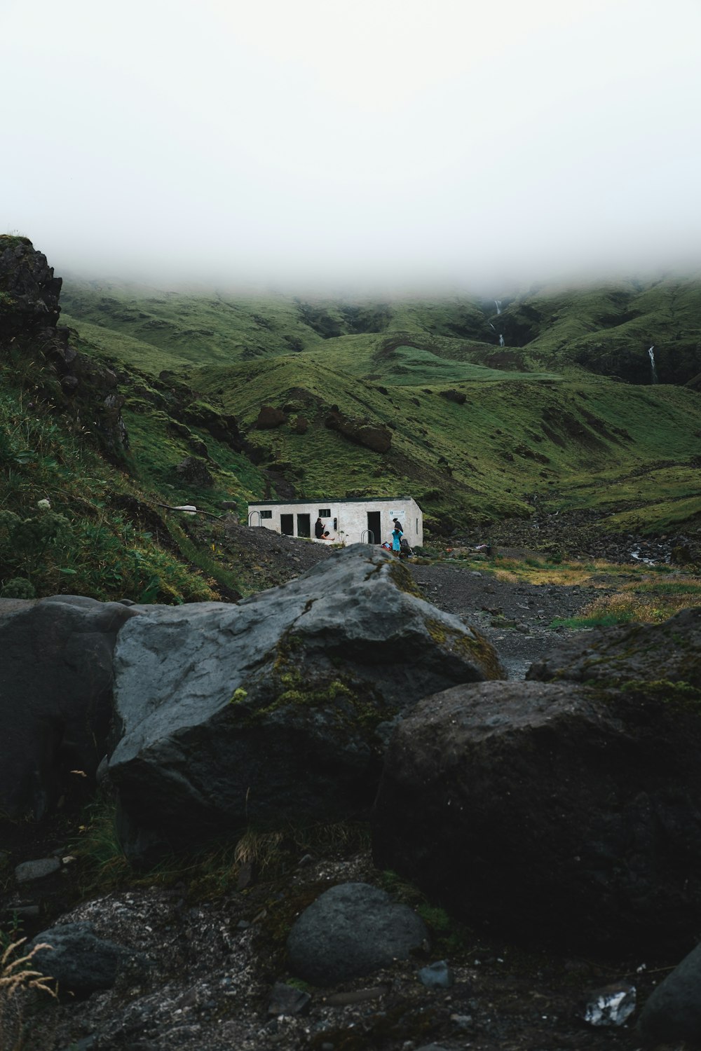 white and green house on top of gray rocky mountain