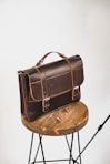black leather sling bag on brown wooden round table