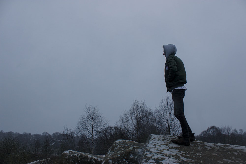 a man standing on top of a snow covered hill