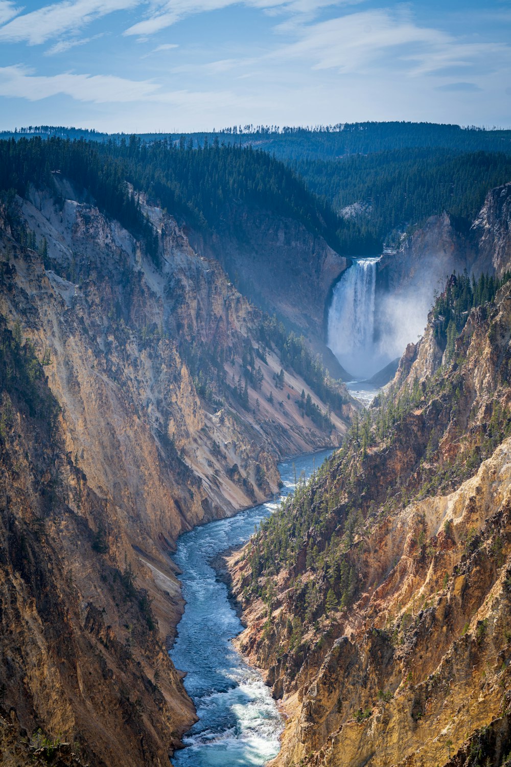 river between brown and green mountains during daytime