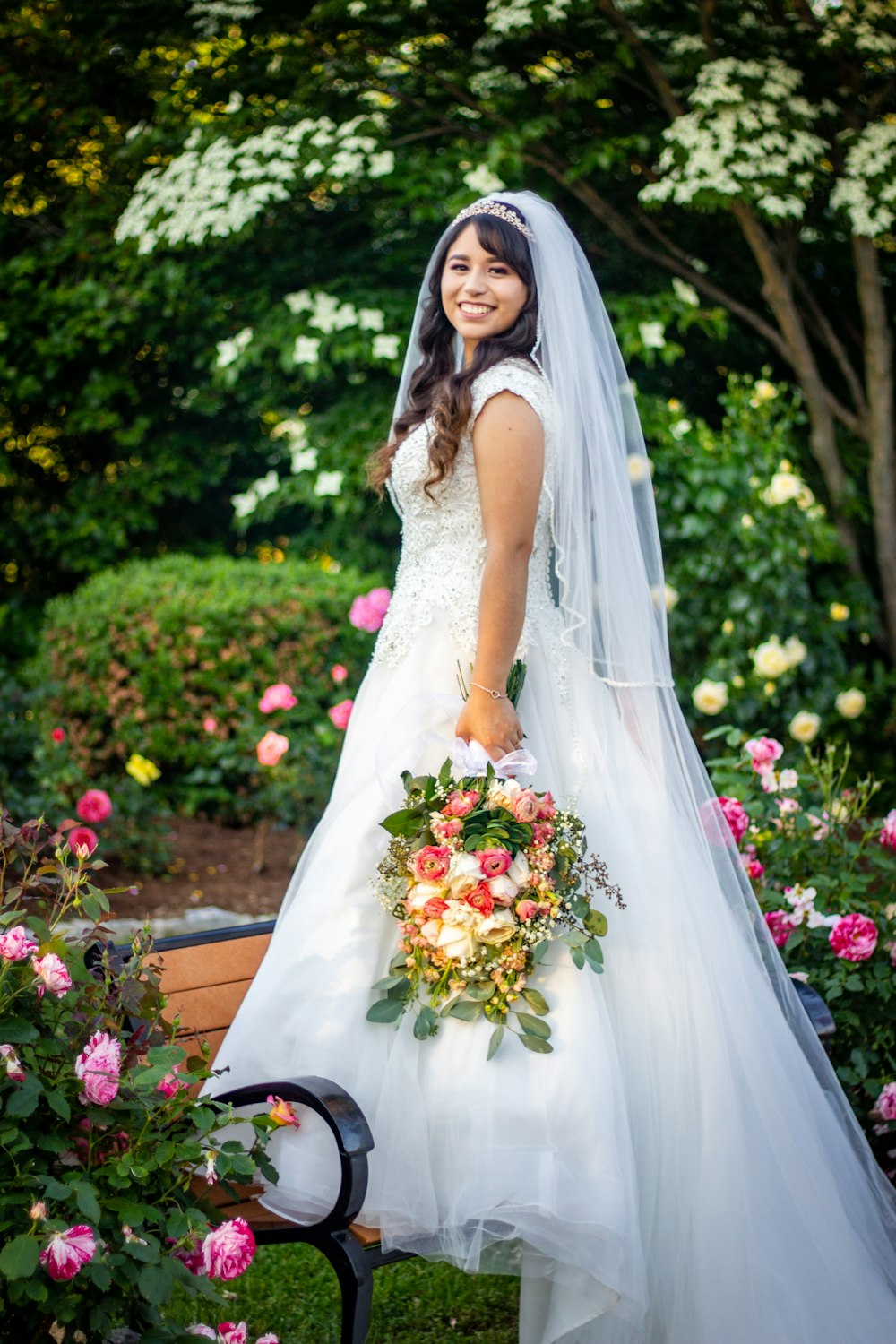 femme en robe de mariée blanche debout près de plantes vertes pendant la journée