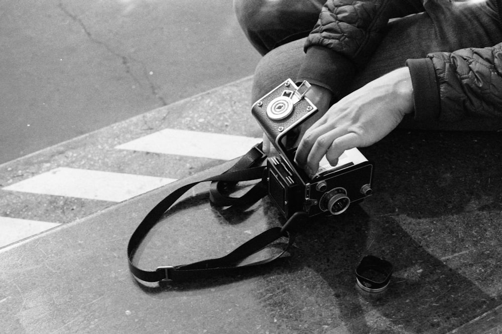 grayscale photo of person holding camera