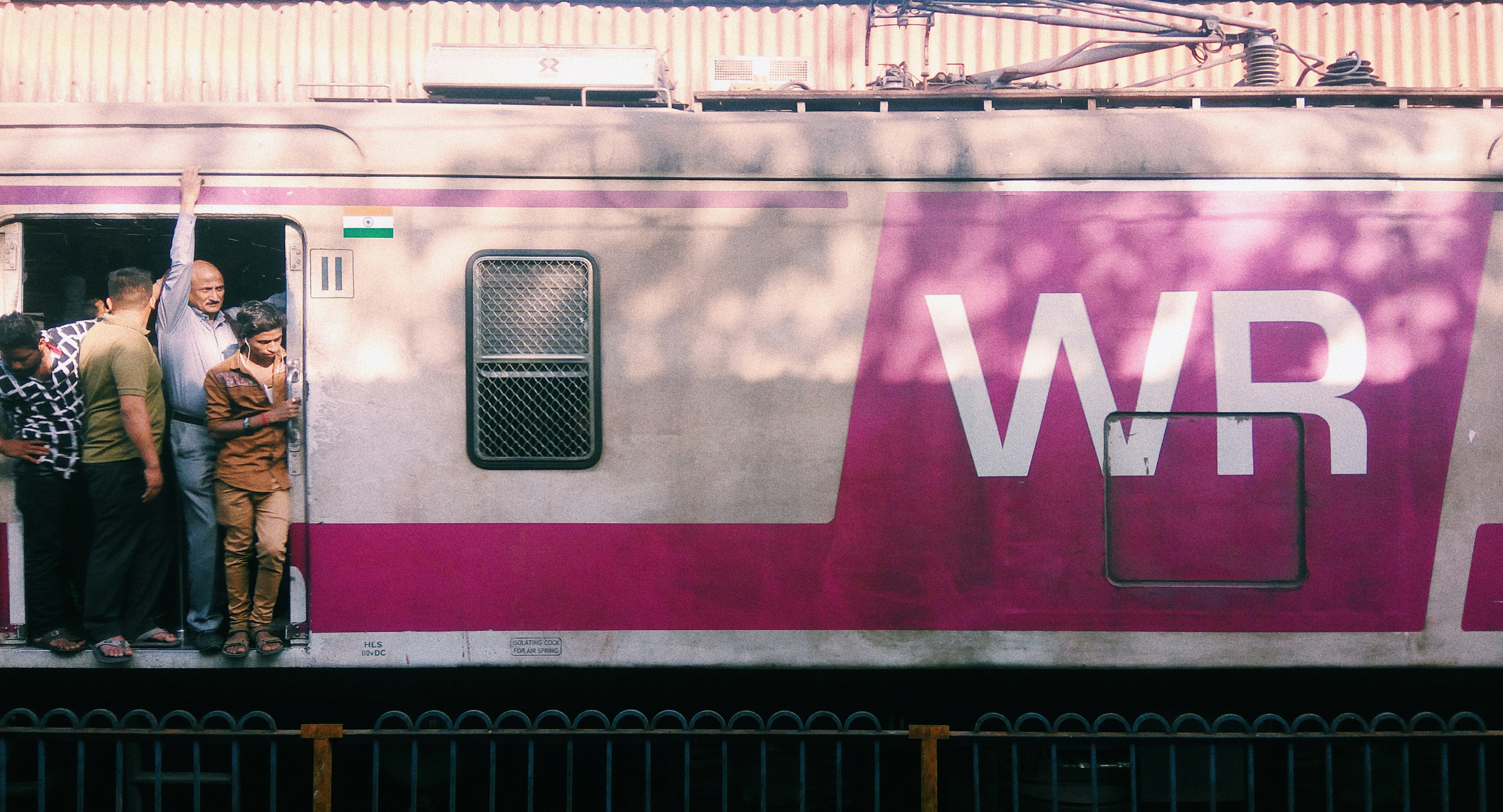 a group of people standing on the side of a train