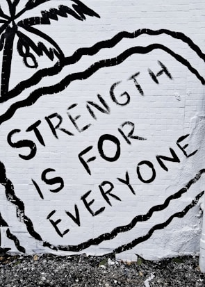 A close-up of a hand-painted sign reading 'Strength in Mind' at a community awareness event.