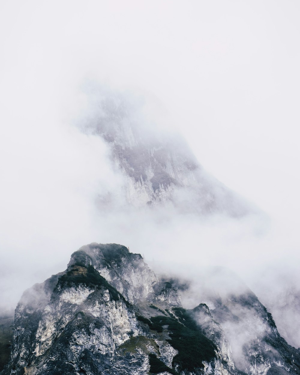 black and white mountain under white clouds