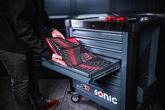 person in black pants and red shoes standing beside black and silver electric keyboard