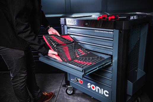 person in black pants and red shoes standing beside black and silver electric keyboard