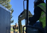 man in black jacket and helmet riding on black tractor during daytime