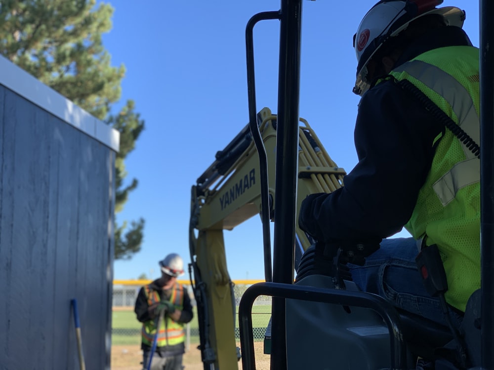 Mann in schwarzer Jacke und Helm fährt tagsüber auf einem schwarzen Traktor