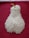 A mound of white rice is arranged in the shape of a pear with a green stem, placed on a textured, deep red fabric background.