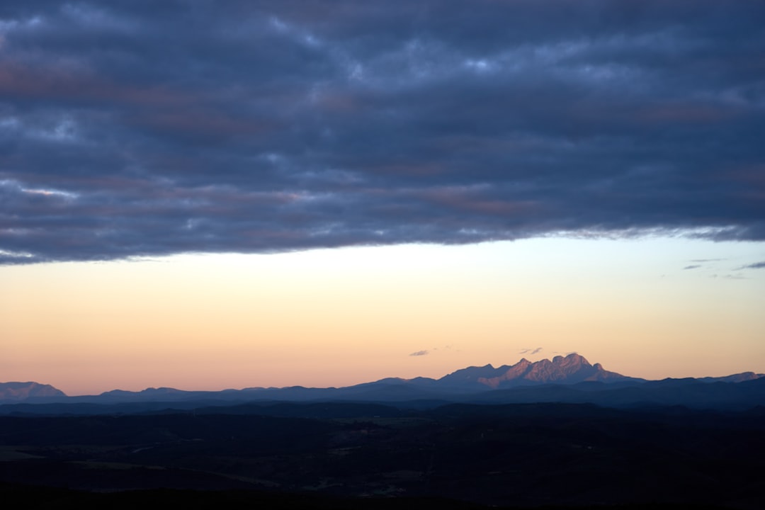 silhouette of mountains under white clouds during daytime