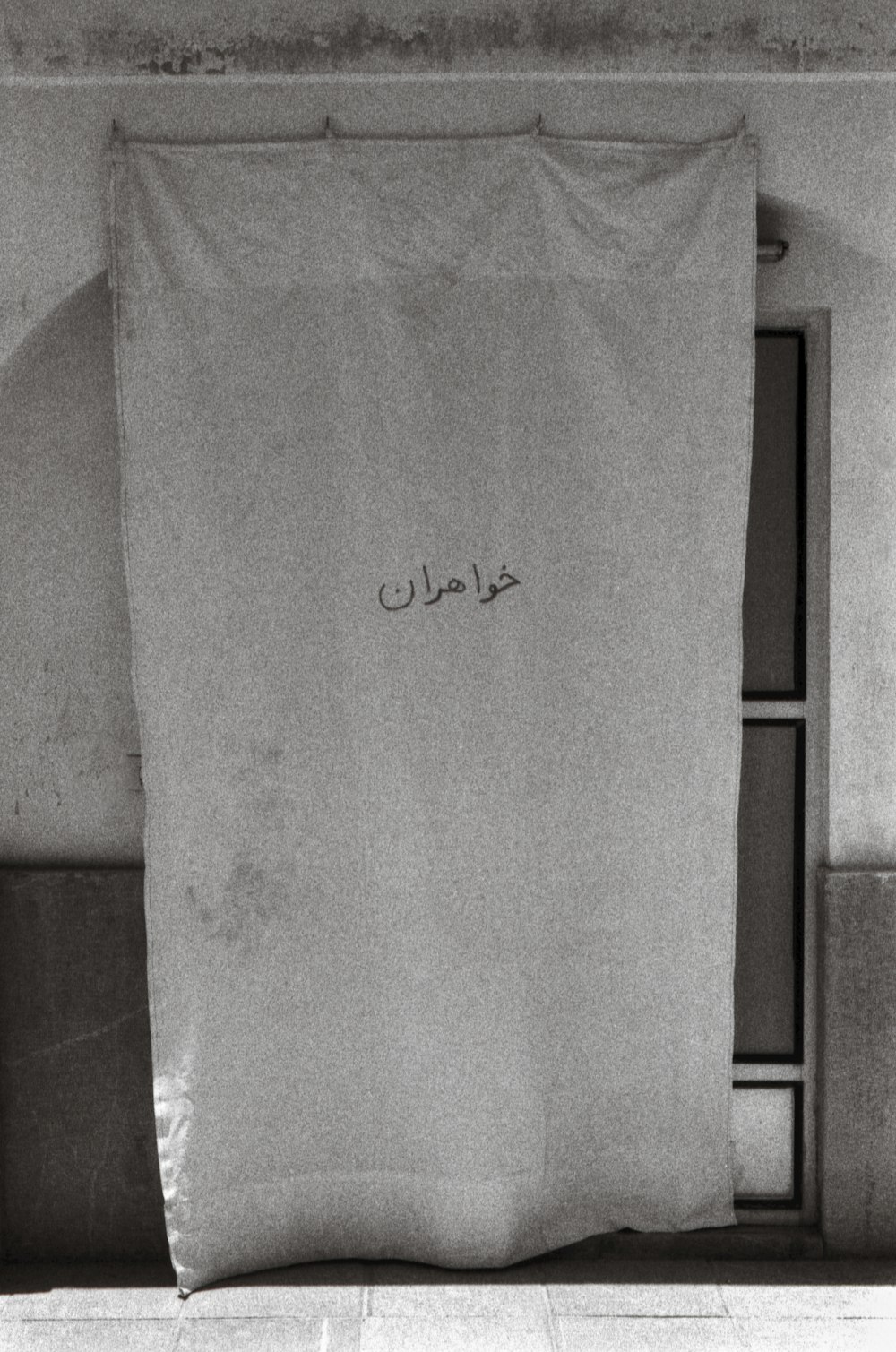 a black and white photo of a curtain with writing on it