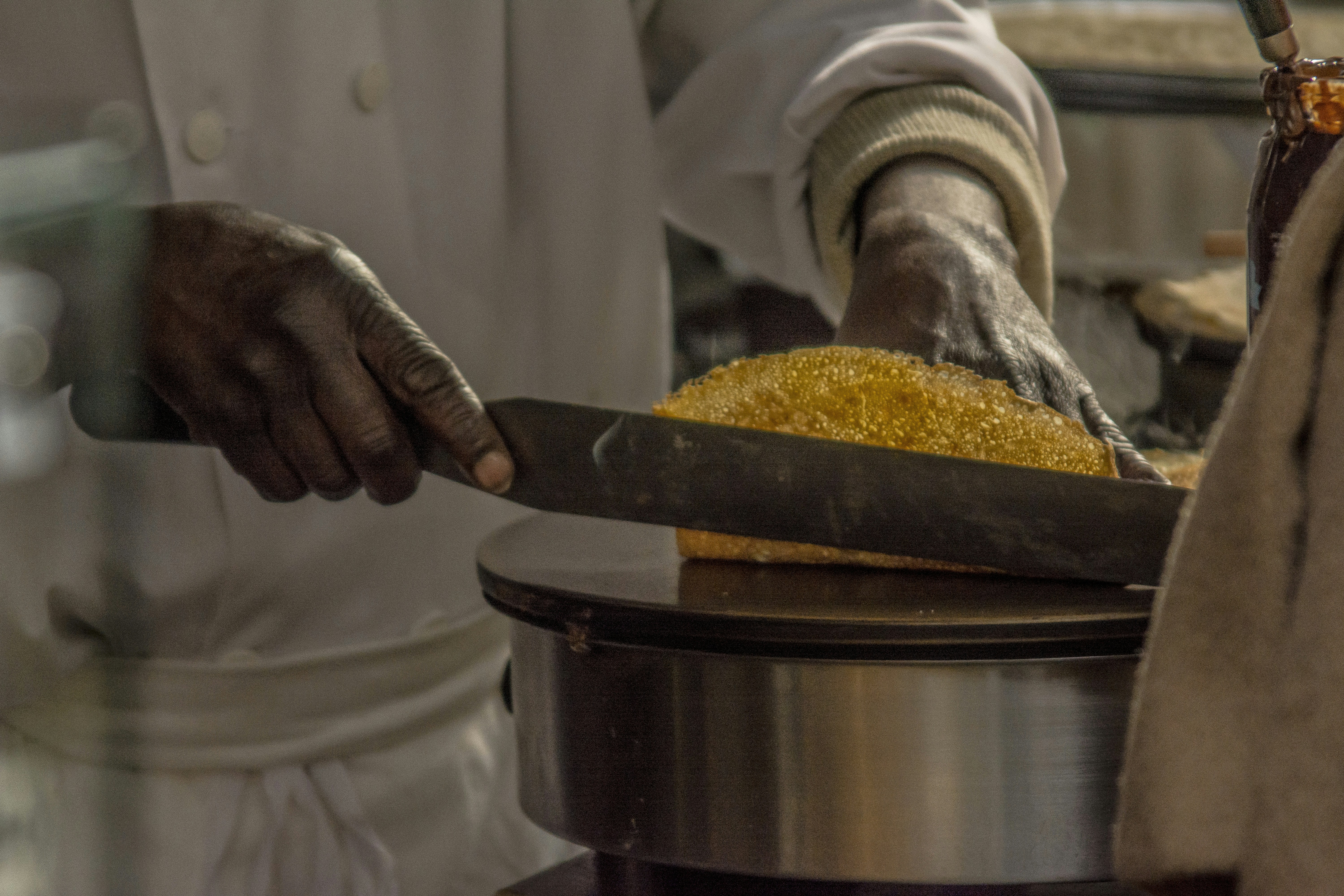 Cook stirring a pot with a knife nearby
