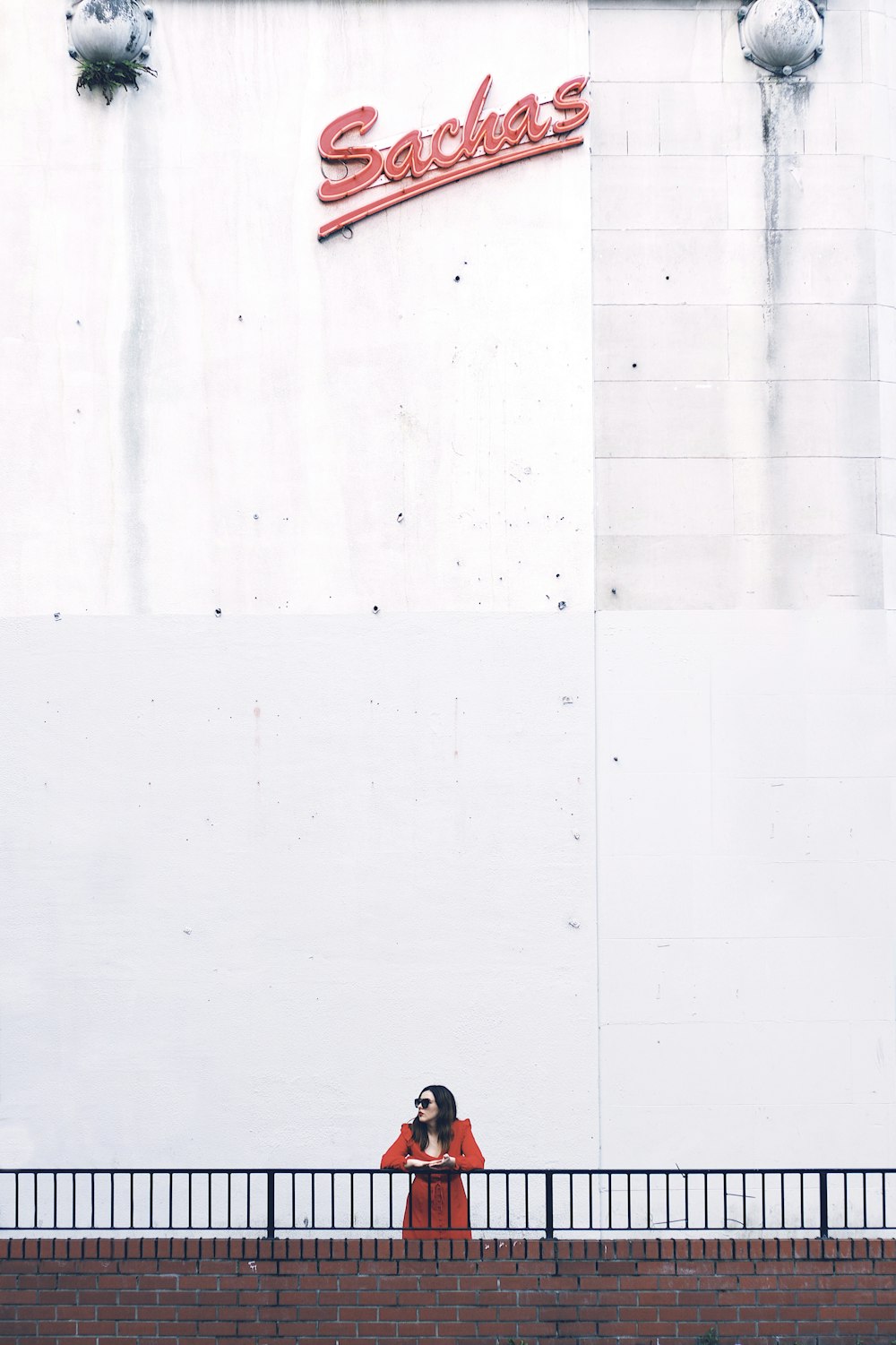 person in black pants walking on white floor tiles