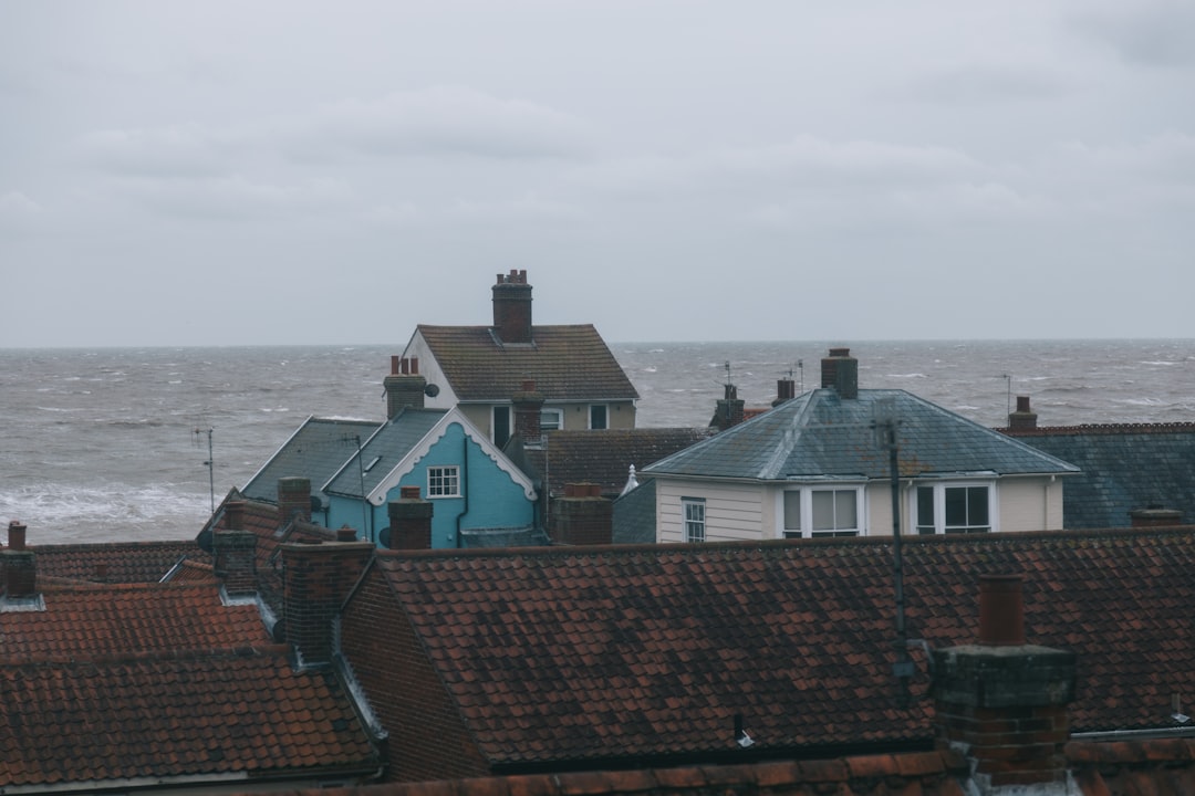 brown and white concrete houses near sea under white sky during daytime