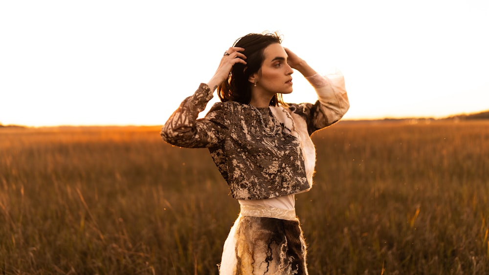 woman in white and black floral long sleeve dress standing on grass field