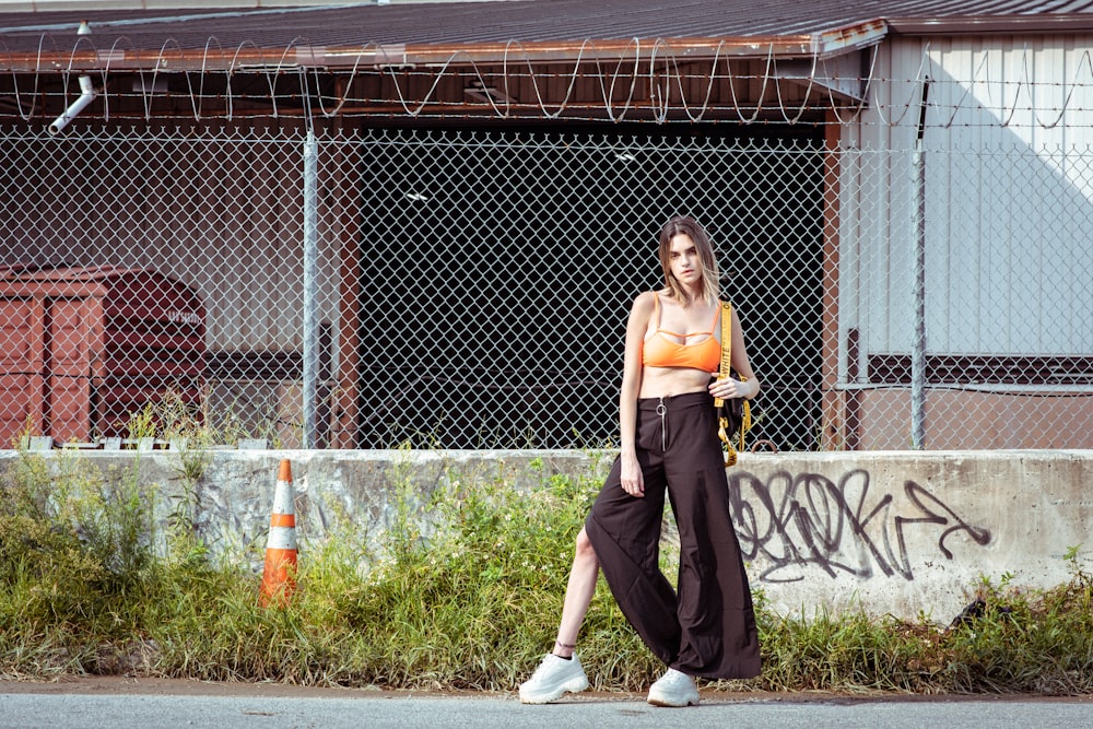 woman in brown pants standing on gray concrete floor during daytime