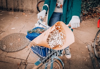 A delivery person carrying a bouquet of flowers to a customer's doorstep.