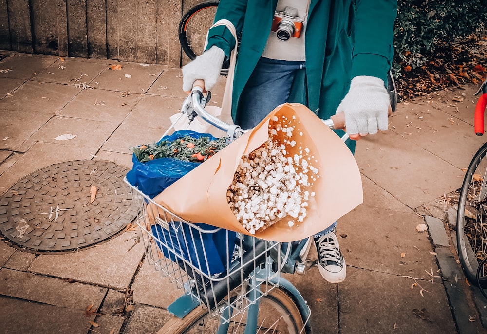 woman in blue jacket and blue denim jeans holding blue shopping cart with brown and white