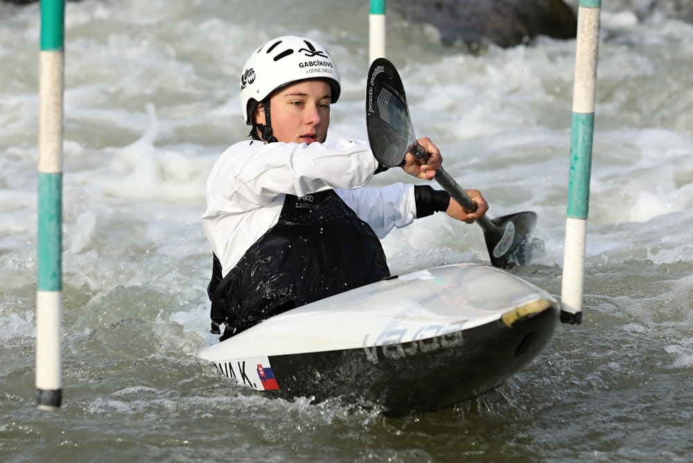 man in white and black wet suit riding white surfboard on water during daytime