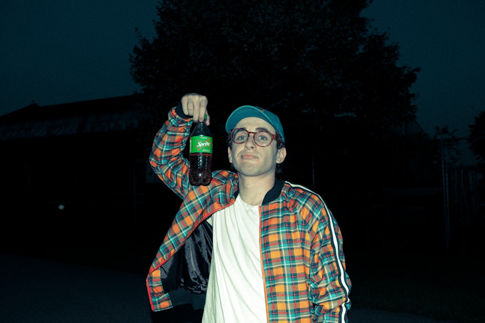 homme en chemise à carreaux bleu, rouge et blanc portant une casquette bleue