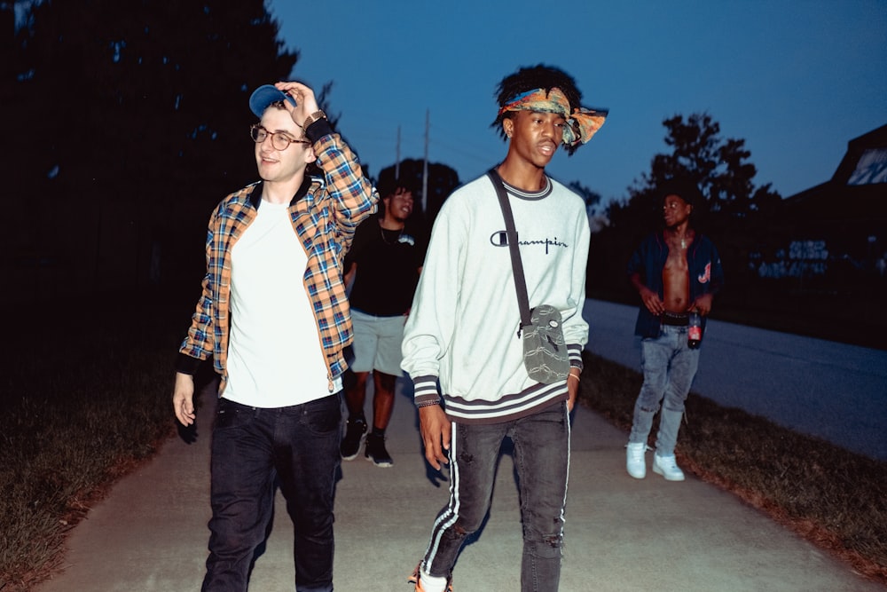 man in white crew neck shirt standing beside man in red and black plaid button up