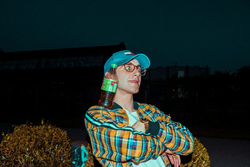 man in yellow and blue plaid dress shirt wearing green cap and eyeglasses