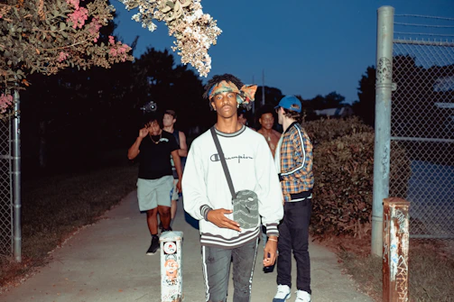 Group of friends in streetwear style hanging out on city steps at sunset.