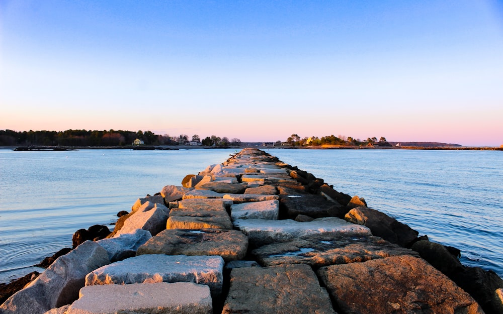 gray rocks near body of water during daytime