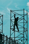 man in green t-shirt and green pants standing on black metal frame