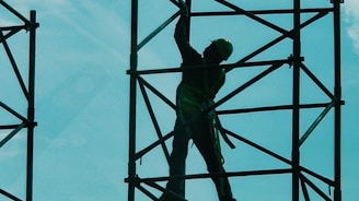 man in green t-shirt and green pants standing on black metal frame