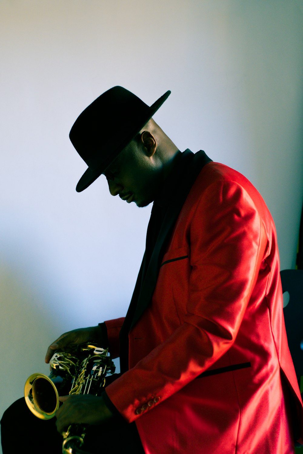 man in red suit jacket and black hat