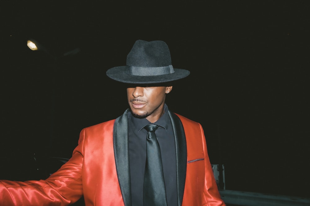 man in black hat and red blazer